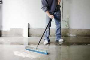 An Xtreme Home Improvement technician removes water from a flooded basement