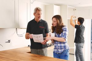 An Xtreme Home Improvement technician discussing home water damage restoration estimates with a home owner